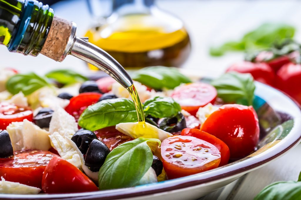 Mixed salad with oil being added