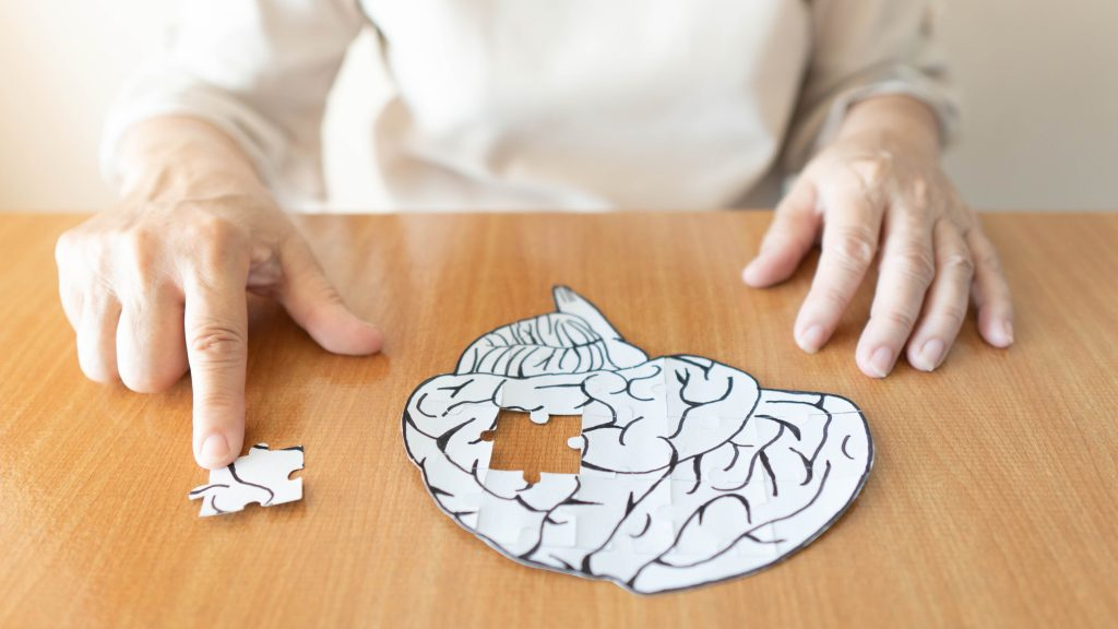 Man completeing puzzle that looks like a brain